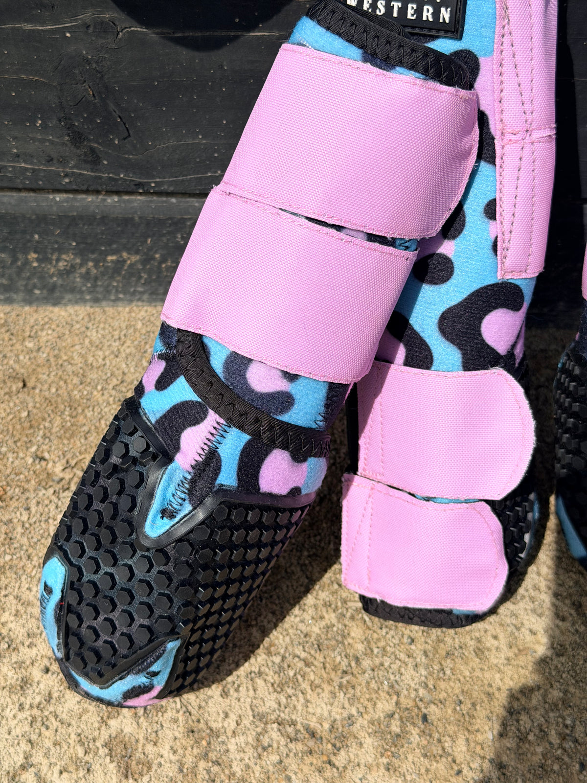 Close-up of pink and blue leopard splint boot with padded closures and black sole panels