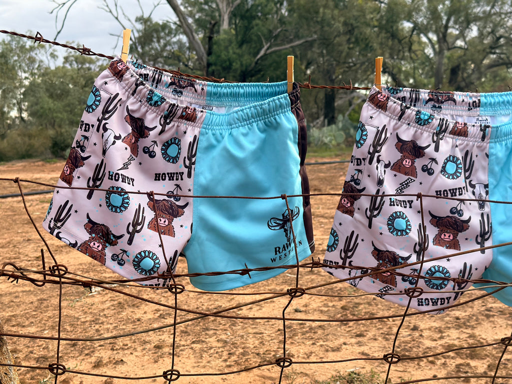Footy shorts pair hanging: white cowboy print on one side and bright blue on the other