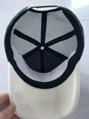 Trucker cap underside view: white crown with dark mesh panels and black mesh top