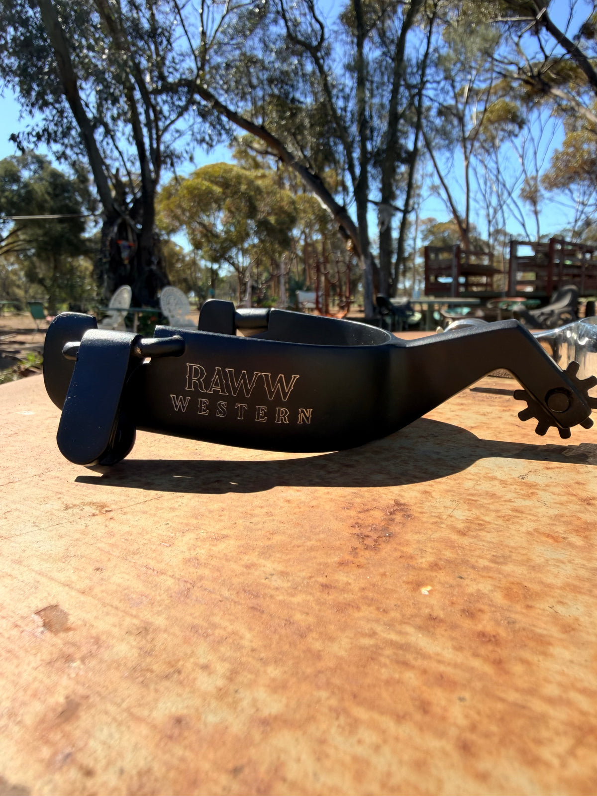 Black Western spurs with metal rowel and RAW WESTERN logo strap