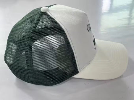 Trucker cap side view: white front panel with dark green mesh back and curved brim