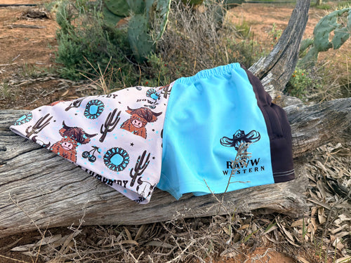 Footy shorts in light blue and white cartoon print with drawstring waist.