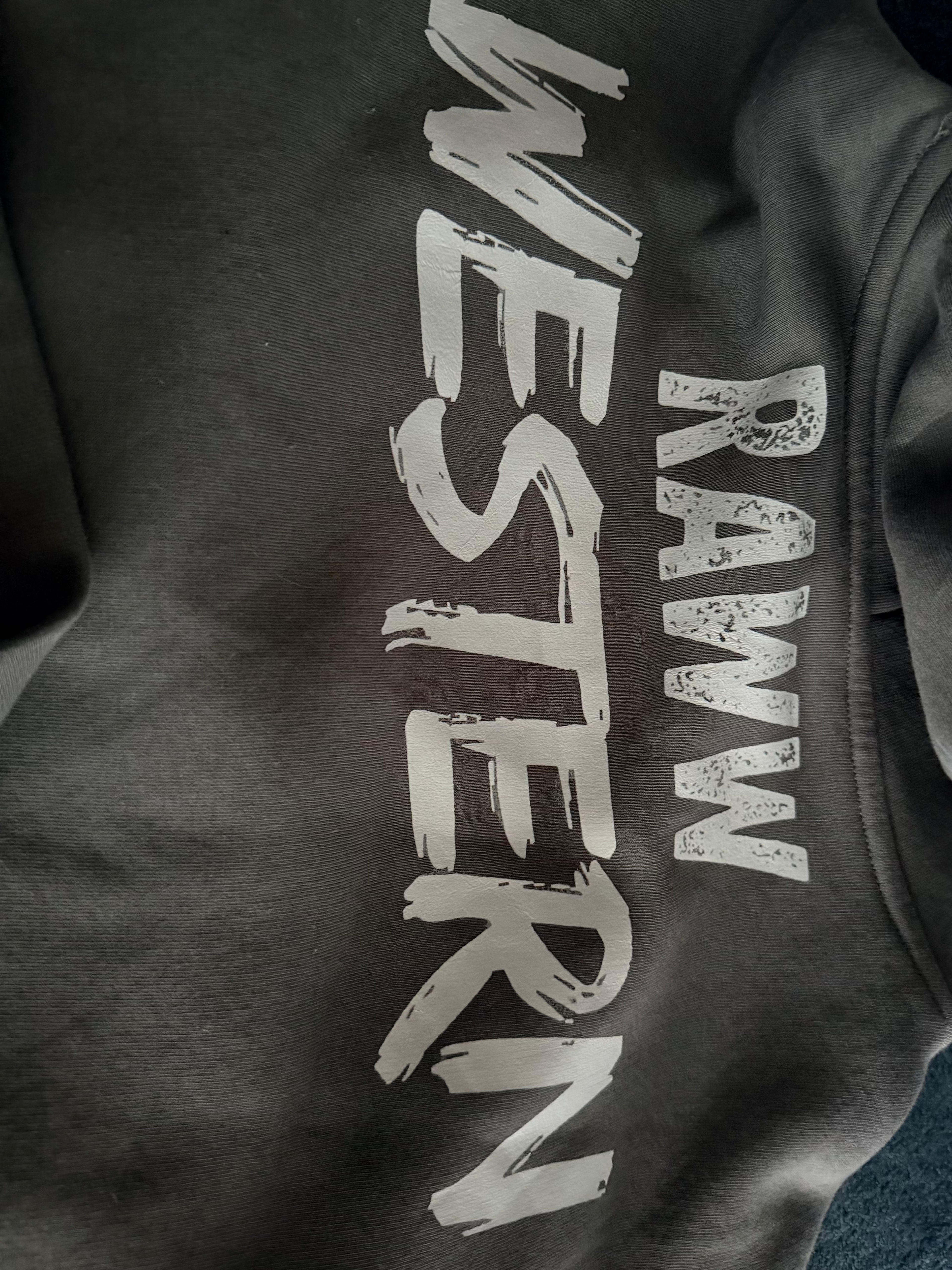 Faded grey hoodie close-up of large Raww Western-style logo print